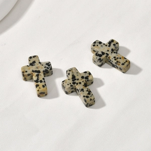 Close-up of Dalmatian Jasper cross charms for DIY jewelry making with pre-drilled holes