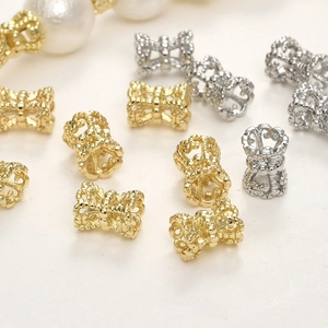 Macro-opname van 14k vergulde bloem- en strikkraaltjes voor het maken van DIY-sieraden