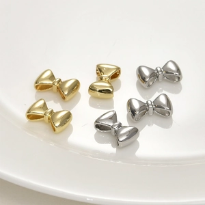 Polished 14k gold and silver bow-shaped metal spacer beads for DIY jewelry making