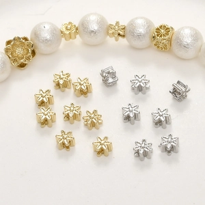Detail van bloemvormige tussenkralen in goud en zilver voor DIY-sieraden