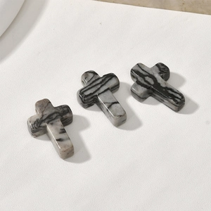 Macro detail of three zebra jasper stone cross pendants for DIY jewelry making