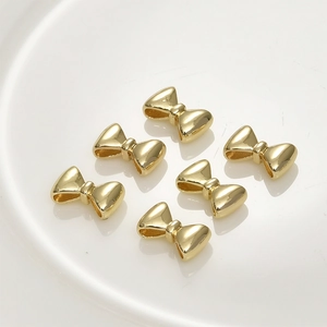 Macro shot of gold-plated bow-shaped spacer beads for DIY jewelry making and beading