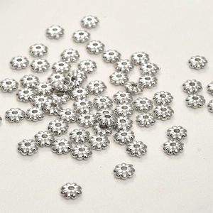 Macro shot of silver plated sunflower spacer beads for DIY jewelry making and crafts