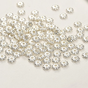 Macro shot of silver flower spacer beads for DIY jewelry making and crafting