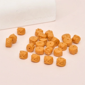Detailed macro view of orange lion dance head resin beads with DIY threading holes