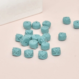 Detailed view of cyan blue lion head resin beads for DIY jewelry and handmade crafts