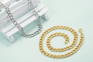 Schicke Gold- und Silber-Cuban-Halsketten mit Pavé-Kristallen auf mintgrünem Grund