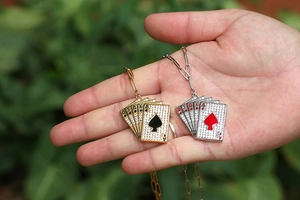 Dettagli dei ciondoli a carte da poker in oro e argento con cristalli di zircone