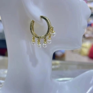 Pendientes de aro dorados minimalistas con cinco perlas de imitación en modelo