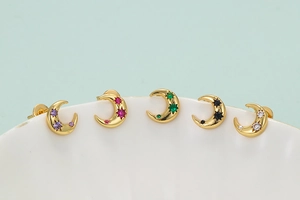 Detail view of five crescent moon stud earrings with colorful zircon star inlays