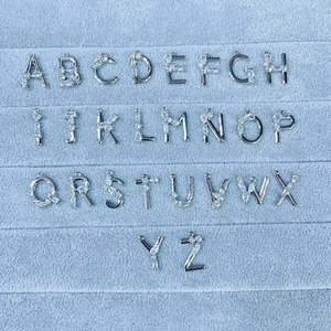 Detailoverzicht van zilveren 18K gouden letterhangers A-Z met fonkelende zirkoniasteentjes