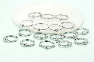 Détails des bagues alphabet en argent serties de zircons sur fond de marbre