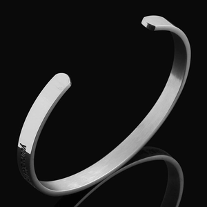 Nahaufnahme des silbernen Titanstahl-Armreifs mit motivierender You are Braver Gravur