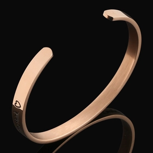 Nahaufnahme der roségoldenen Titan-Manschette mit gebürstetem Finish und Herz-Gravur
