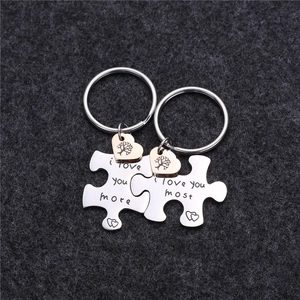 Close-up of puzzle couple keychains with heart tree charms and engraved romantic text