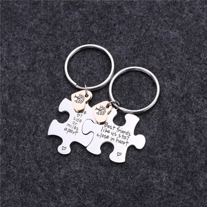 Detailed macro view of puzzle piece keychains with engraved text and tree of life charms