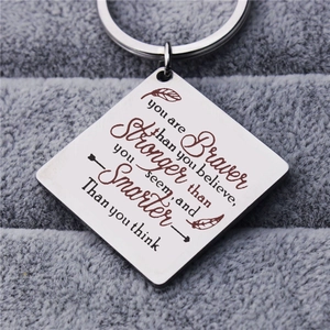 Polished stainless steel keychain with engraved inspirational quote and feather pattern
