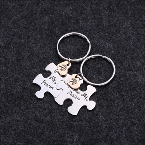 Detail of puzzle piece keychains with You're My Person text and rose gold hearts
