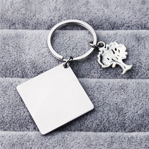 Minimalist titanium steel keychain with square tag and tree charm on grey velvet