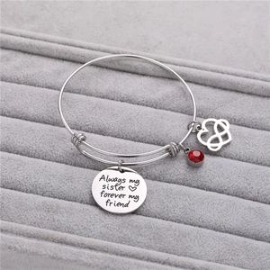 Dettaglio del bracciale sorella in argento con pietra portafortuna rossa e ciondoli