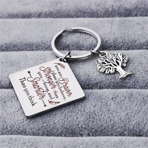 Titanium steel square keychain with life tree charm and inspirational quote on gray stand