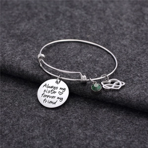 Dettaglio del ciondolo inciso e della pietra portafortuna verde sul bracciale argento