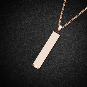 Macro view of polished rose gold rectangular bar pendant necklace on a black background