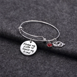 Dettaglio del bracciale argento con ciondolo inciso e pietra portafortuna rossa