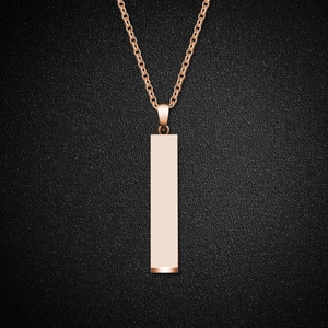 Minimalist geometric bar pendant necklace in rose gold stainless steel on black surface