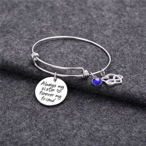 Dettaglio del bracciale argento con pietra portafortuna blu e ciondolo a cuore inciso