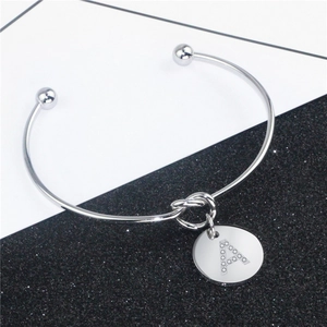 Détail du bracelet argenté avec nœud et pendentif lettre A orné de strass