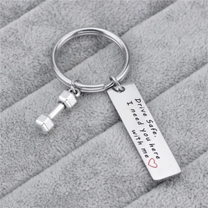 Titanium steel drive safe keychain with dumbbell charm on grey velvet display tray