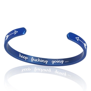 Macro detail of blue brushed titanium steel cuff with keep fucking going engraving