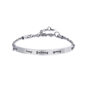 Gros plan détaillé de la plaque du bracelet en acier titane poli avec gravure motivante