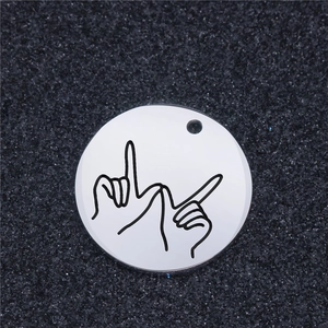 Macro shot of silver stainless steel round pendant with artistic gesture engraving