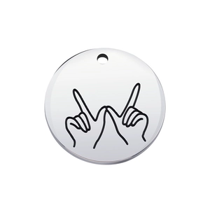 Macro shot of silver stainless steel round pendant featuring a line art hand gesture