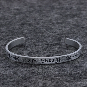 Dettaglio del bracciale rigido in acciaio argentato con incisione I Am Enough