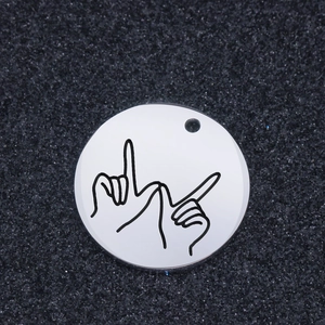 Polished stainless steel round pendant with sign language engraving on black background