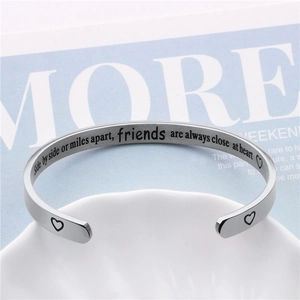 Offenes Armband aus Titanstahl mit Gravur zur Freundschaft auf strukturiertem Tablett