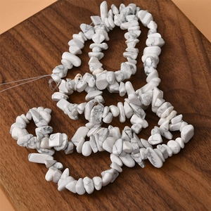Natural irregular turquoise beads necklace arranged on a rustic wooden tray for DIY jewelry
