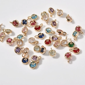 Close-up of 14k gold plated four-leaf clover charms with colorful zircon gemstones