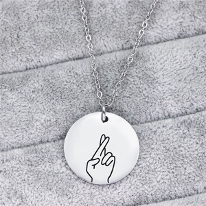 Collana con ciondolo a moneta in argento lucido con gesto portafortuna a dita incrociate