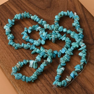 Irregular turquoise stone beads for DIY jewelry on a dark walnut wood background