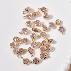 Detailed macro view of pink crystal clover pendants with gold plated rings for DIY jewelry