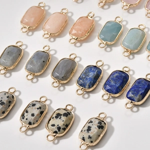 Detailed macro view of faceted rectangular gemstone connectors with gold-plated double loops