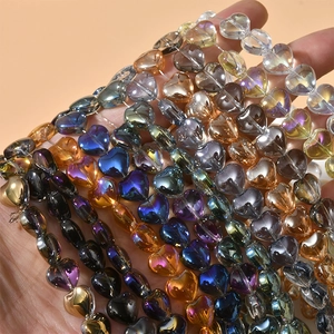 Close-up of heart-shaped crystal glass beads with vibrant iridescent AB coating for DIY crafts