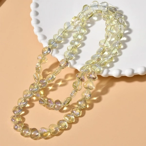 Detailed view of heart-shaped iridescent glass beads on a white decorative plate