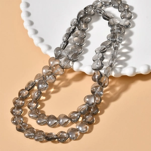 Macro detail of heart-shaped grey crystal glass beads for DIY jewelry making and crafts