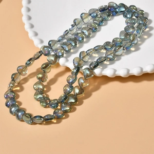 Macro detail of iridescent heart-shaped glass beads with colorful metallic luster