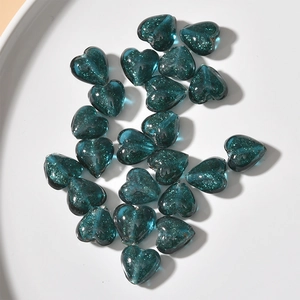 Detail of dark blue heart-shaped glass beads with glitter for DIY jewelry making